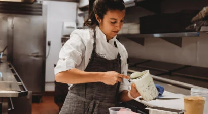 Female chef scooping.