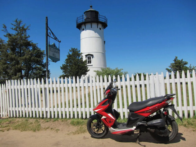 Motorcycle in front of lighthouse.